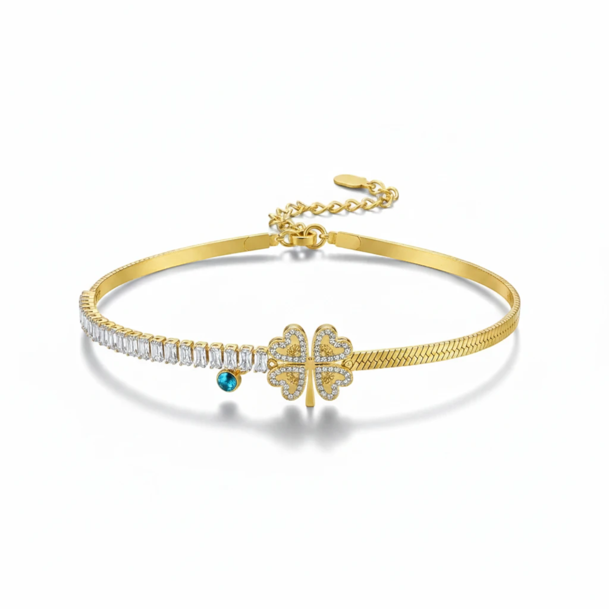 MiRA armband i guldtonat rostfritt stål med fyrklöver, gnistrande stenar och en blå detalj.