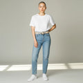 MiRA beige skärp i veganskt läder med silverfärgat spänne buret av en korthårig modell i vit t-shirt och jeans.