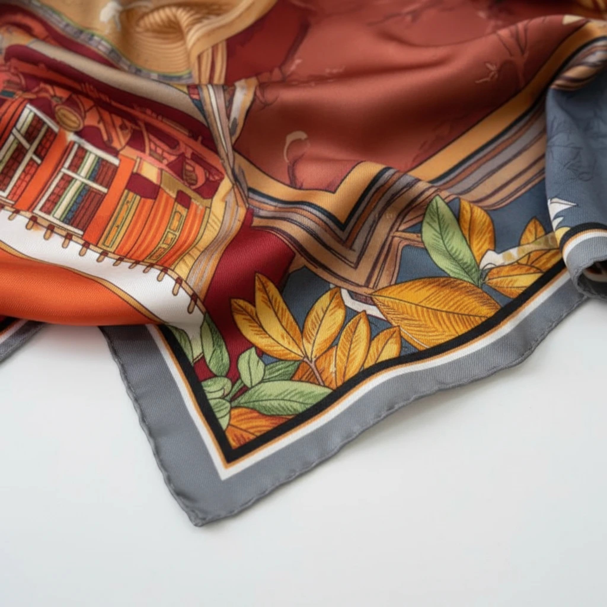 MiRA scarf i mjuk polyester med färgglatt blommönster och arkitektoniska detaljer i rött, orange och grått.