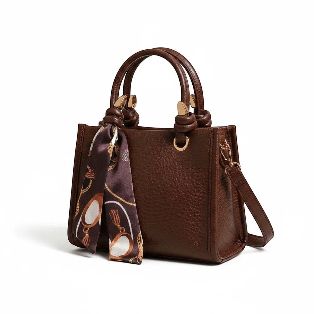 MiRA brun crossbody-väska i konstläder med handtag, axelrem och en dekorativ mönstrad scarf.