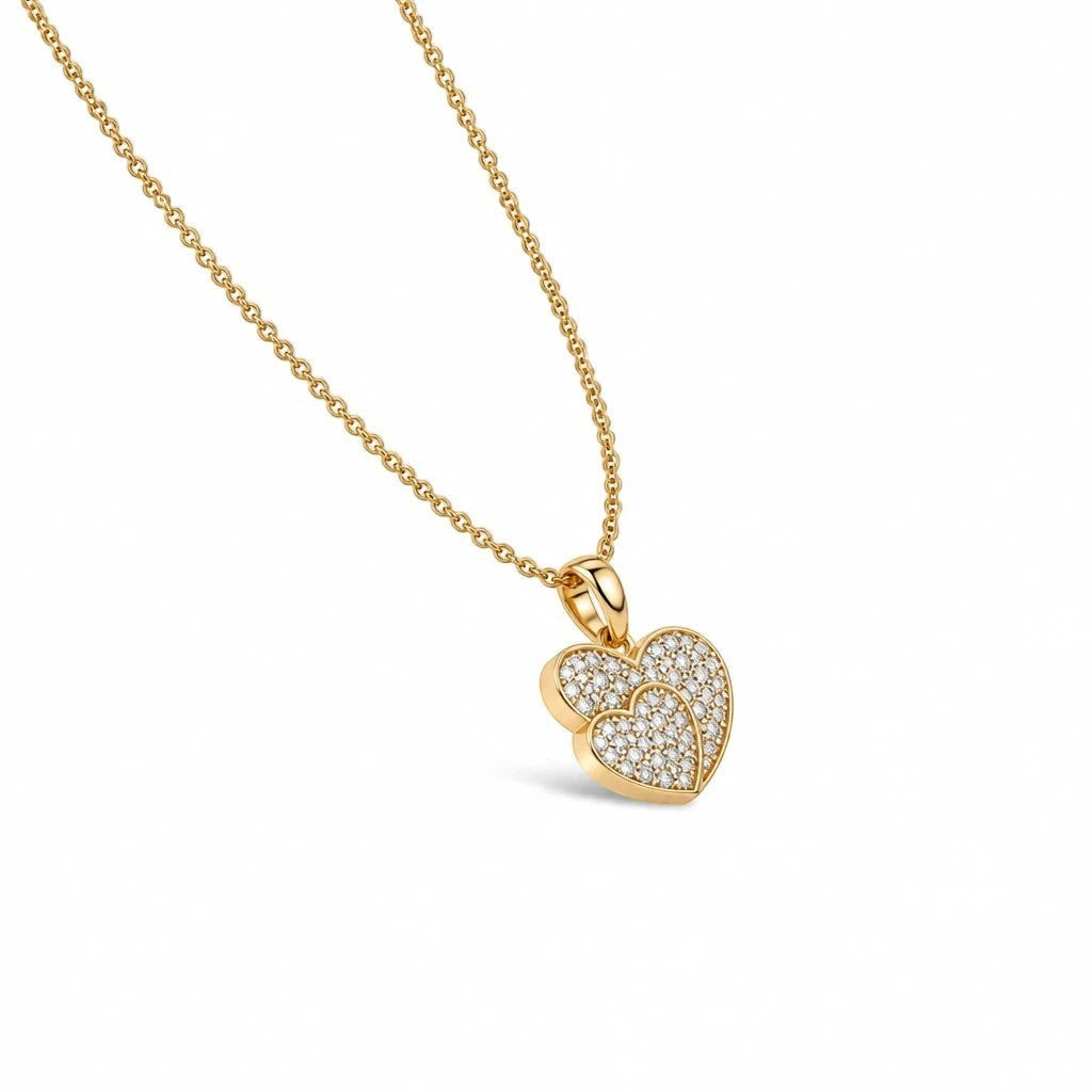 MiRA halsband i guld med ett hjärtformat hänge prytt med gnistrande stenar för en elegant och minimalistisk stil.