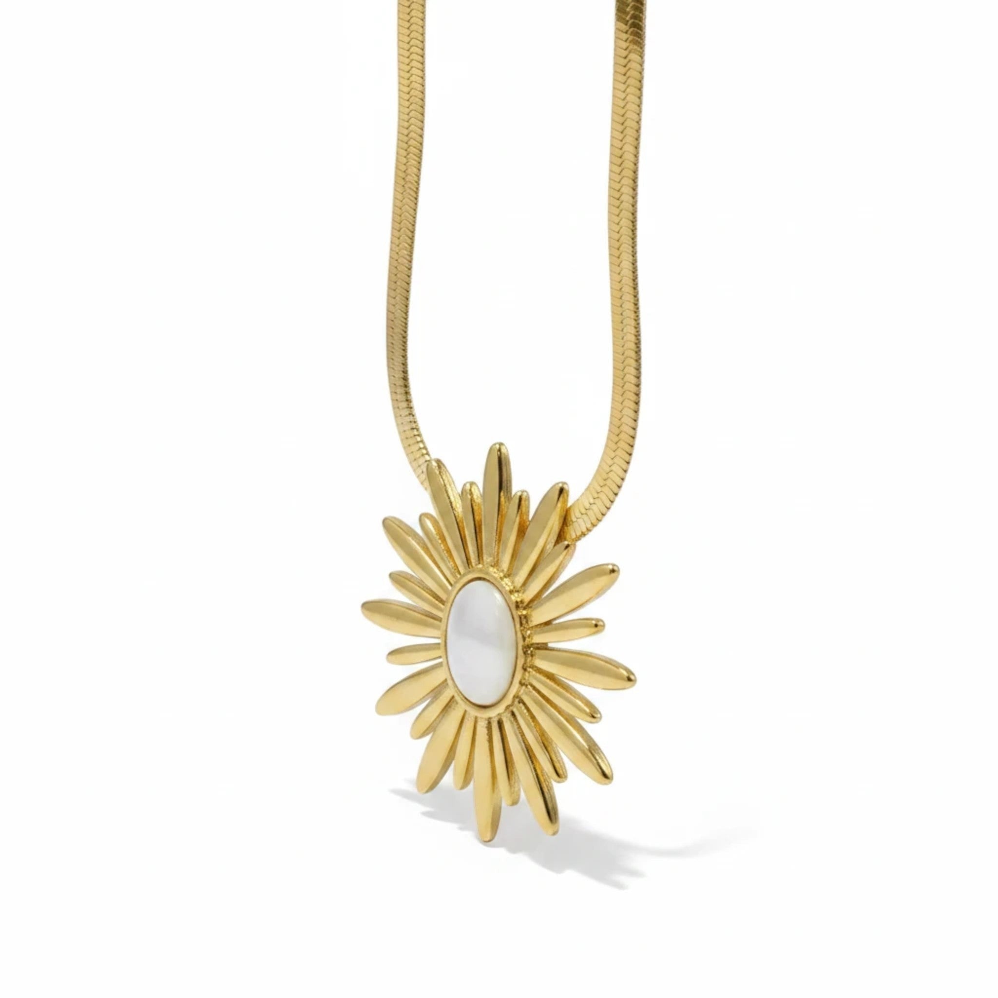 MiRA halsband i guldpläterat rostfritt stål med ett solformat hänge och en vit sten i mitten.