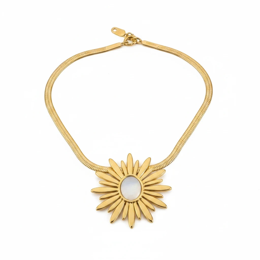 MiRA halsband i guldpläterat rostfritt stål med ett solformat hänge och en elegant ormlänkskedja.