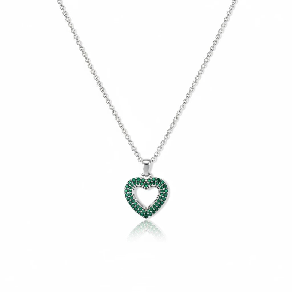 MiRA halsband i rostfritt stål med hjärtformat hänge prytt av gröna stenar och en elegant silverfärgad kedja.