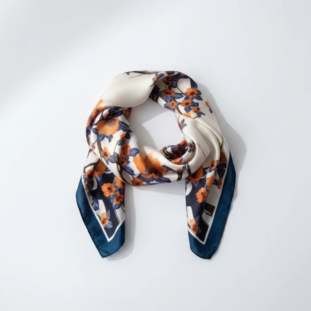 MiRA mönstrad sjal i polyester med blommigt motiv i orange och blått på vit botten.