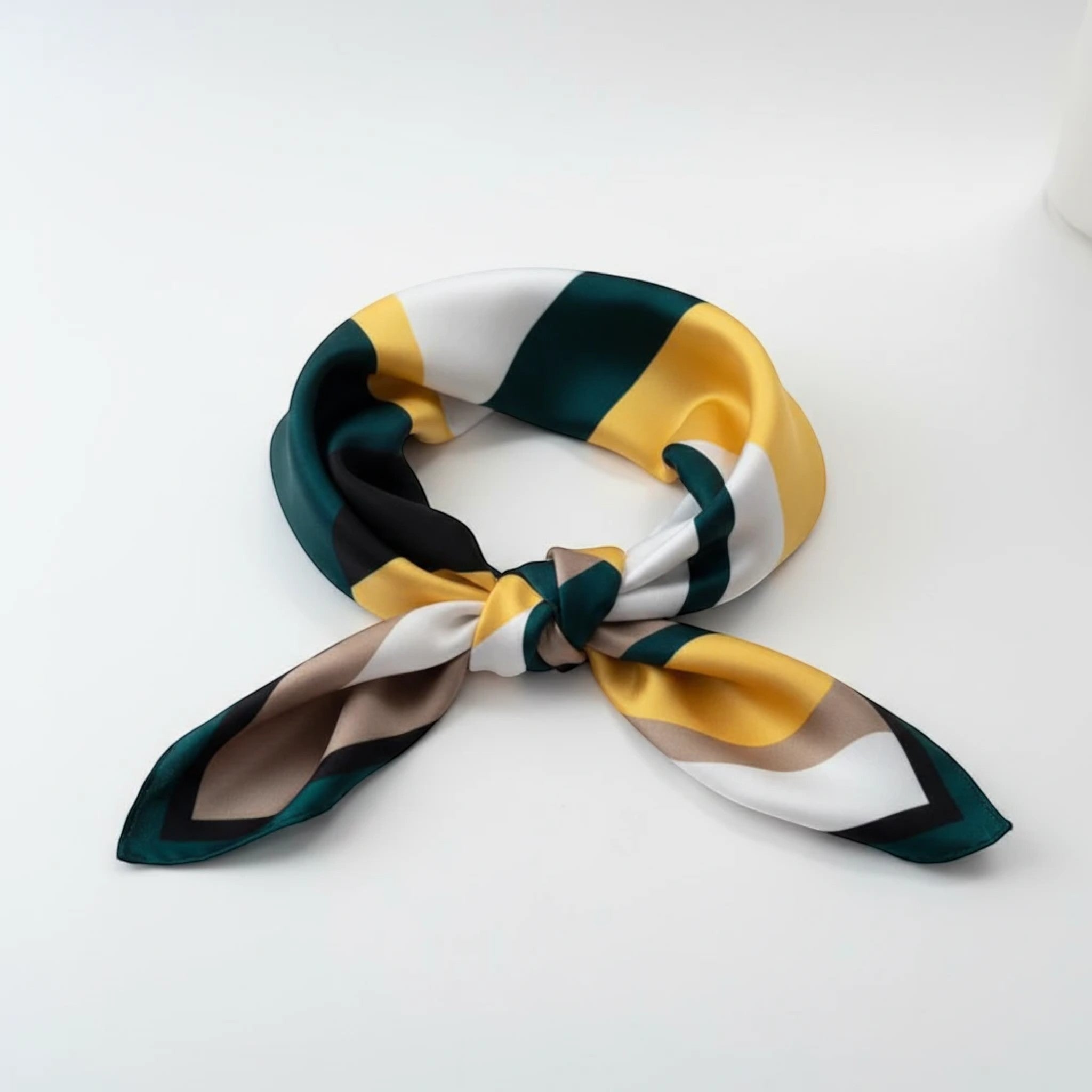 MiRA halsduk i polyester med randigt mönster i gult, grönt och vitt knuten i en elegant knut.