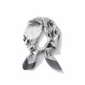 MiRA scarf i sidenliknande polyester med svartvitt bambumönster och elegant lyster, knuten i en klassisk stil.