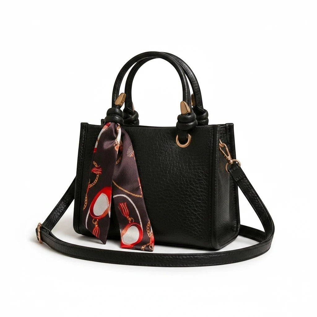 MiRA svart crossbody-väska i veganskt läder med handtag, justerbar axelrem och en dekorativ mönstrad scarf.