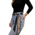 MiRA svart scarf-bälte med prickigt och paisleymönstrat tyg, buret i jeans för en elegant och stilren look.