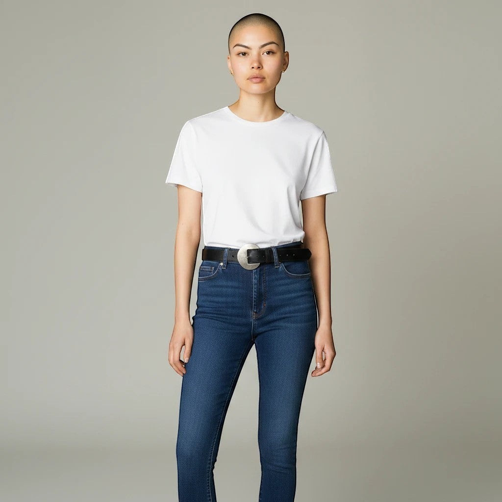 MiRA svart skärp i veganskt läder med silverspänne buret av en modell i vit t-shirt och blå jeans