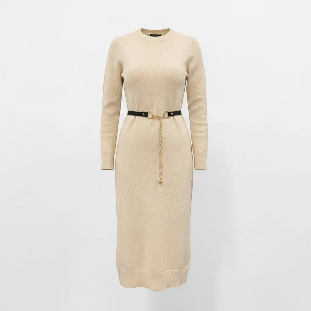 MiRA skärp i svart veganskt läder med ett elegant runt guldspänne och dekorativ kedja, buret över en beige klänning.
