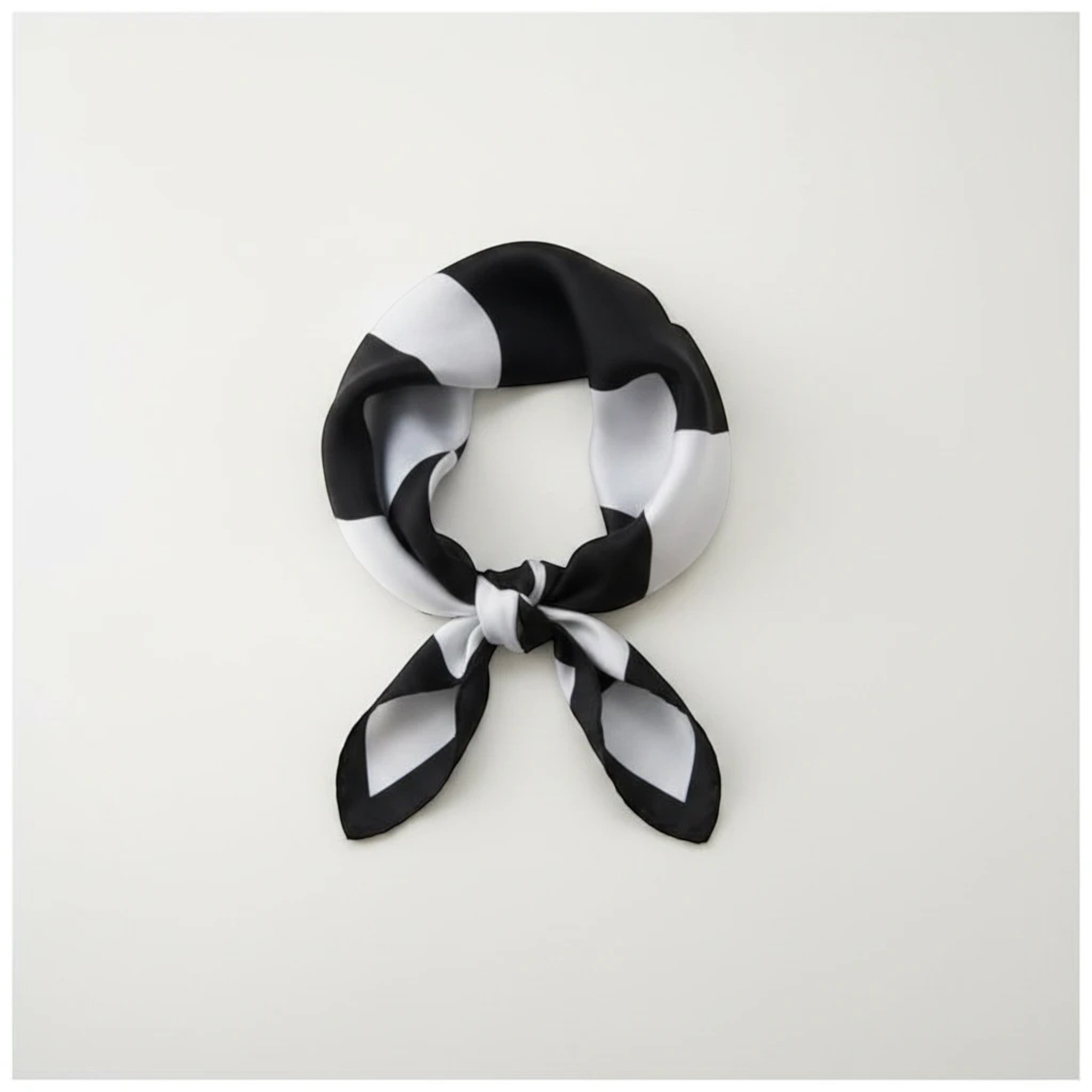 MiRA scarf i mjuk polyester med svartvitt geometriskt mönster, knuten som en elegant accessoar.