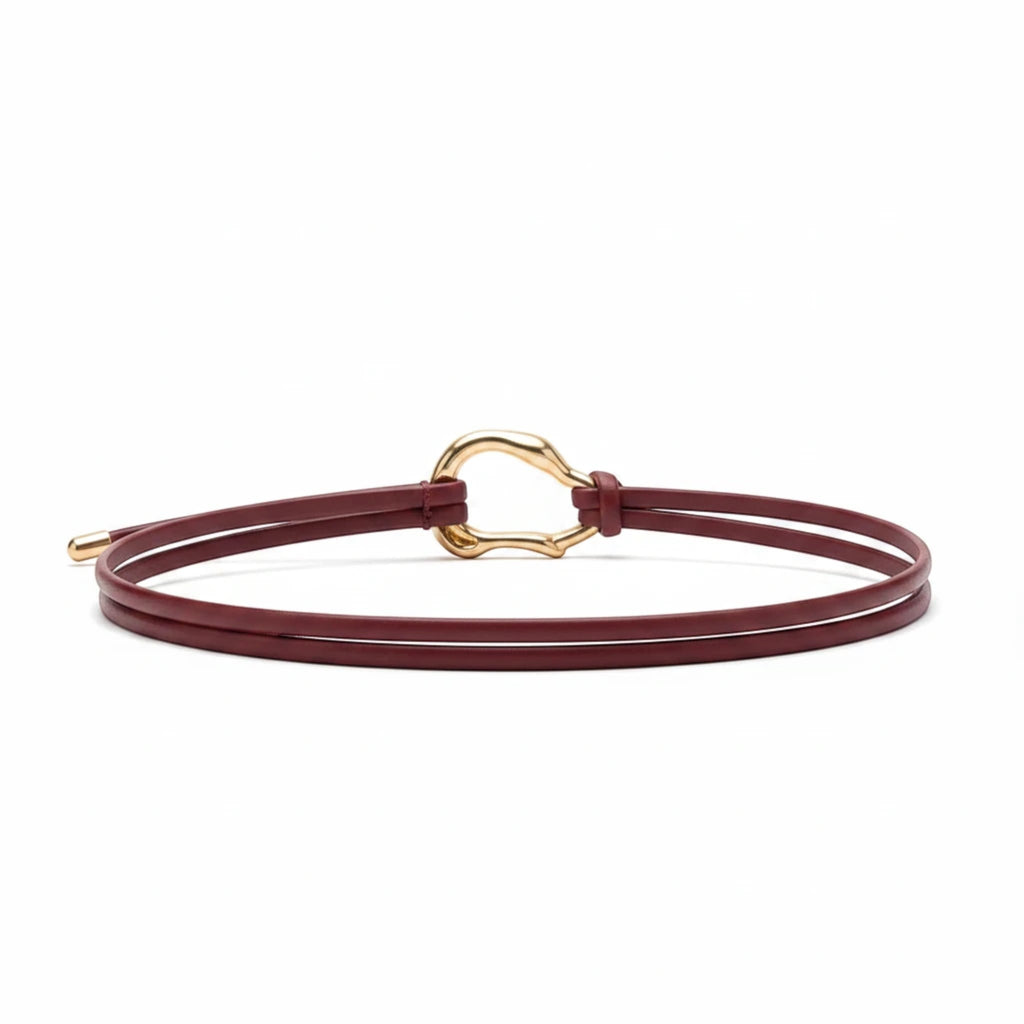 MiRA vinrött knytbälte i veganskt läder med ett elegant guldfärgat dekorativt spänne och smal design.